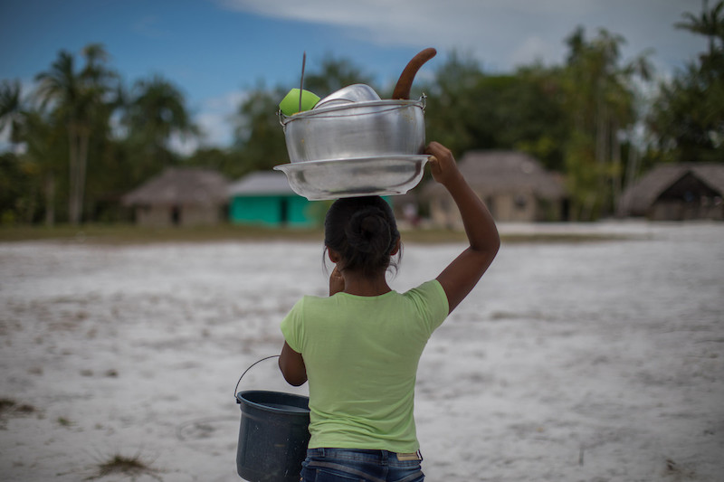 Menina baniwa carrega louça na comunidade Canadá, próxima ao rio Ayari, na Terra Indígena Alto Rio Negro (AM) @Carol Quintanilha / ISA