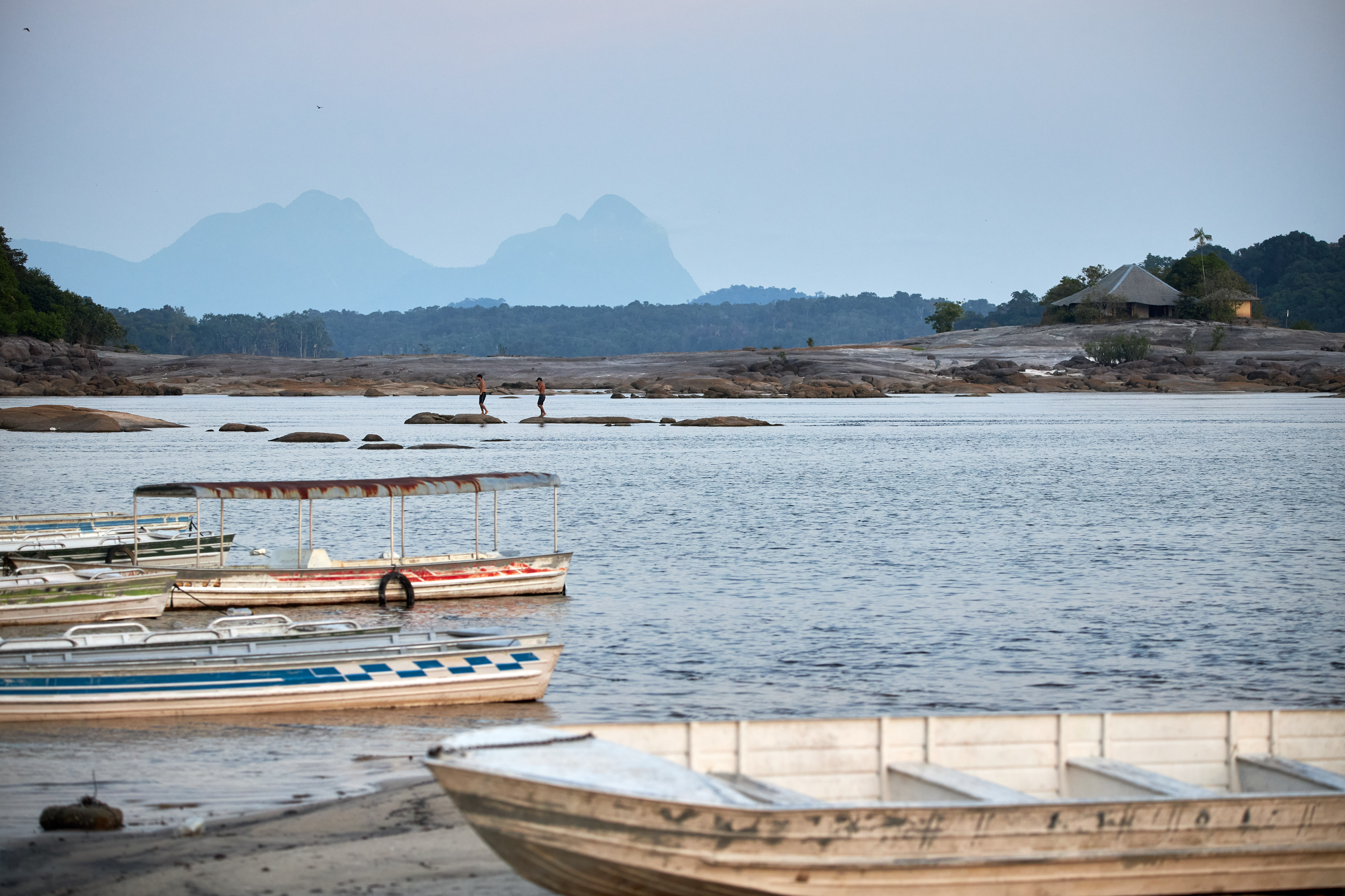 Jovens andam sobre as pedras em meio ao Rio Negro|João Claudio Moreira/Divulgação