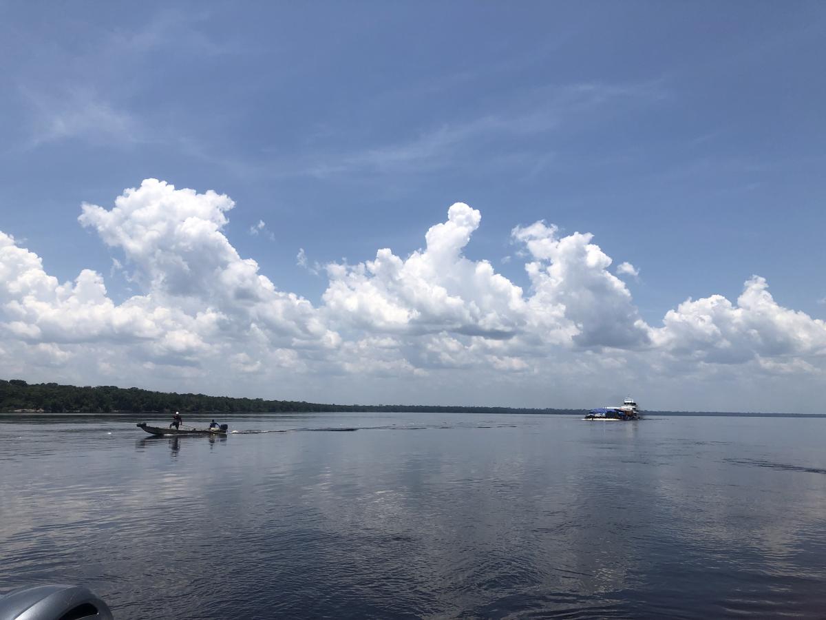 Barco pequeno segue à frente indicando trajeto seguro para balsa com carga, no rio Negro, em Santa Isabel do Rio Negro. Procedimento é comum em época de seca.