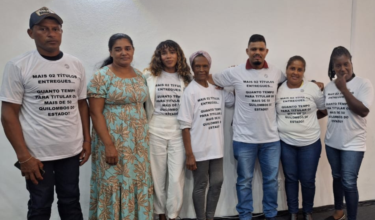 Durante o evento, quilombolas presentes foram impedidos de usar a camiseta e subir ao palco com o seguinte questionamento: Quanto tempo para titular os mais de 50 Quilombos do estado?