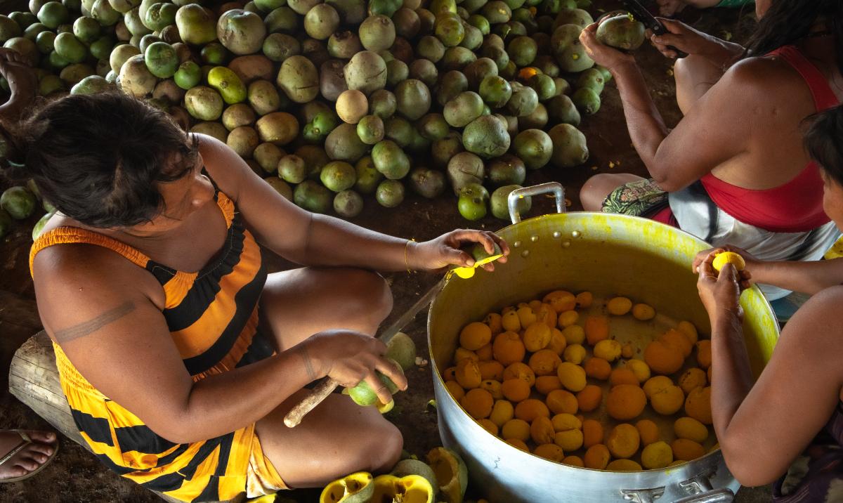 Mulheres do povo Khisêtjê descascam pequi