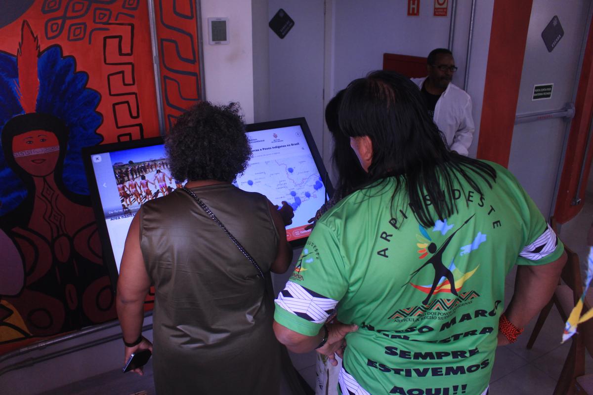 Visitantes interagindo com o Mapa Interativo Povos e Terras Indígenas no Brasil, durante o evento de lançamento do Mapa