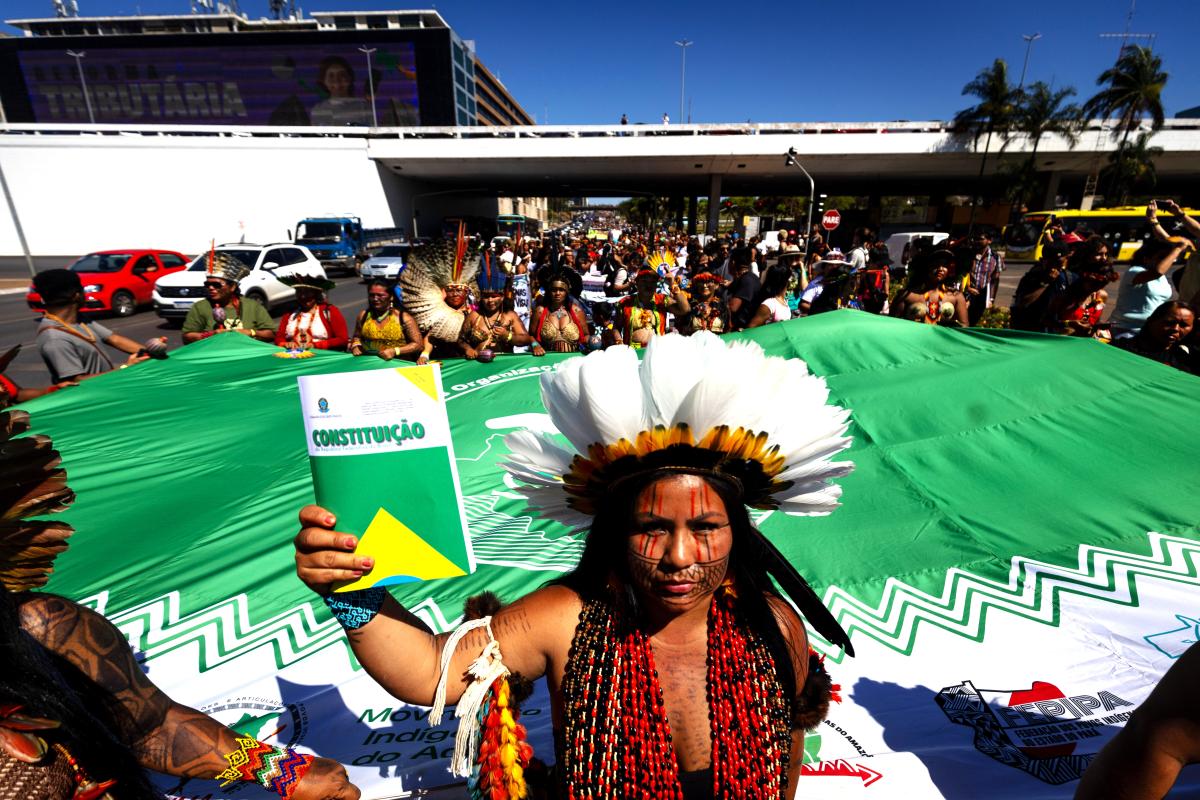 Indígena segura a Constituição na 3ª Marcha das Mulheres Indígenas, em 2023, em Brasília 📷 Webert da Cruz Elias / ISA
