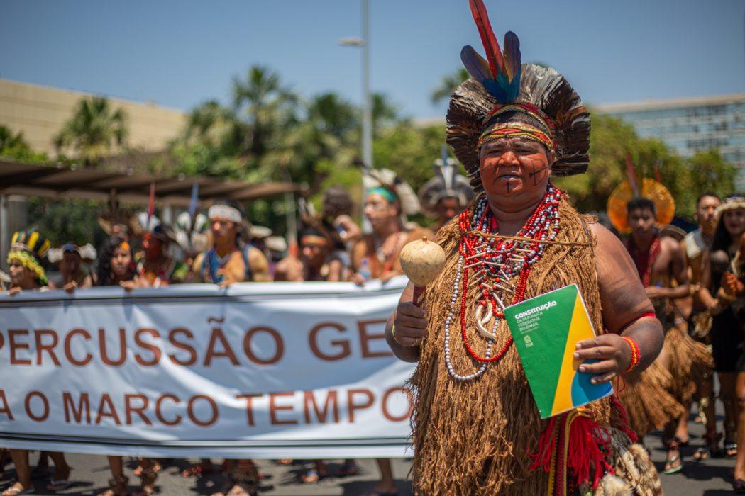 Indígena segurando a Constituição durante Marcha Pataxó e Tupinambá por demarcação de terras e contra o marco temporal, em Brasília | Tiago Miotto / Cimi